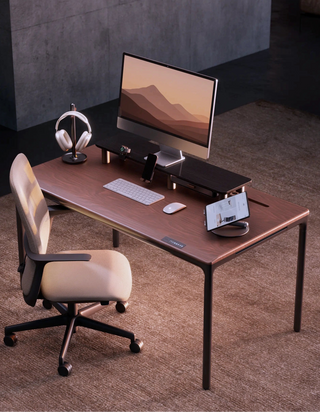 Modern beflo Tenon office desk with computer setup and chair in a room with gray walls.