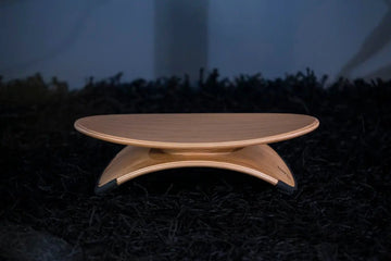 Wooden footrest with a unique design on a dark textured surface